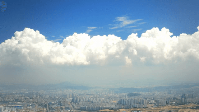 Cityscape under a vast blue sky with clouds