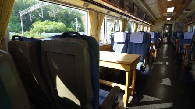 Inside a daytime train with sunlight shining through the windows