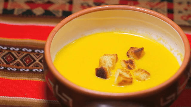 크루통이 올려진 노란 수프 한 그릇