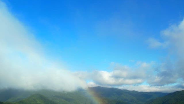 Scenic View of Foggy Mountains with a Faint Rainbow