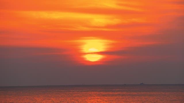 Red sunset coloring the calm and peaceful sea