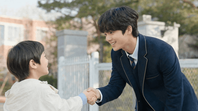 Student and child shaking hands outdoors