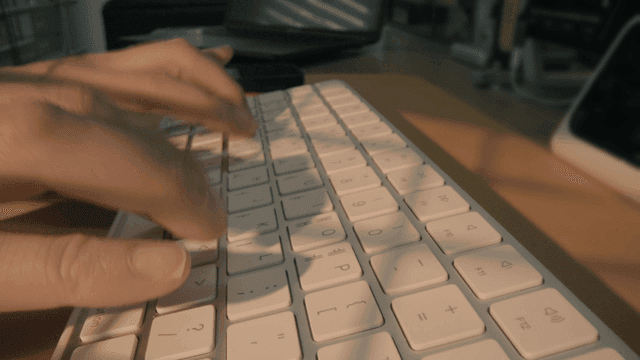 Hands typing fast on keyboard