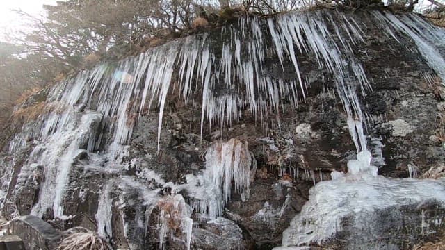 Icicles on a rocky cliff in a cold winter landscape