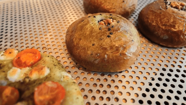 토마토가 올려진 갓 구운 포카치아와 깨가 올려진 빵