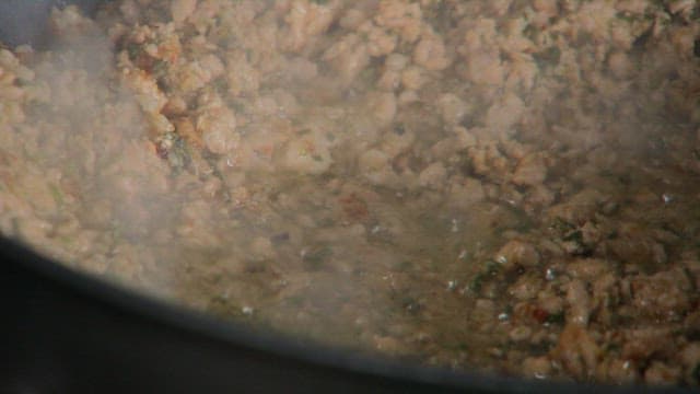 다진 고기를 볶고 있는 팬에 설탕을 넣기