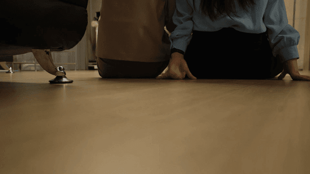 Mother and daughter sitting on floor and watching TV from behind