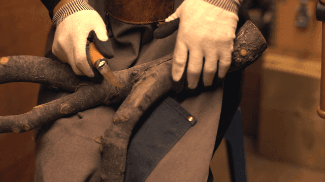 실내에서 나무를 조각하는 사람