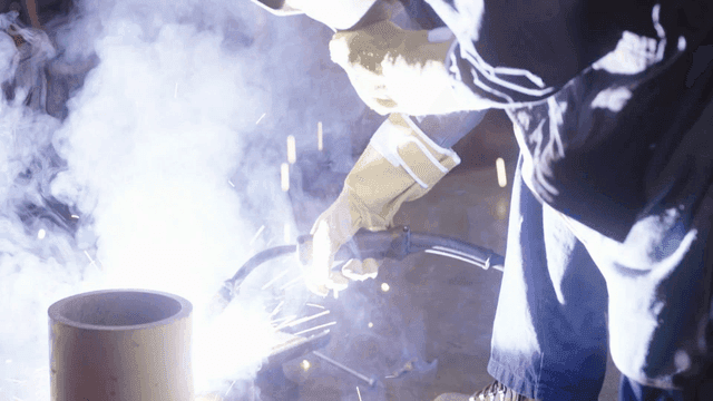 Worker welding metal in a workshop