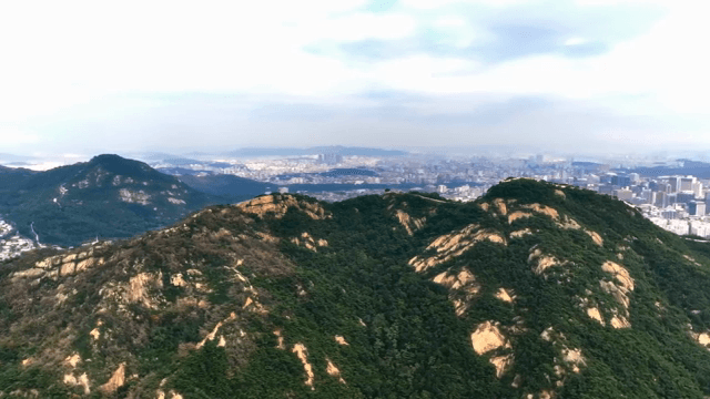 멀리 도시 스카이라인이 보이는 산맥