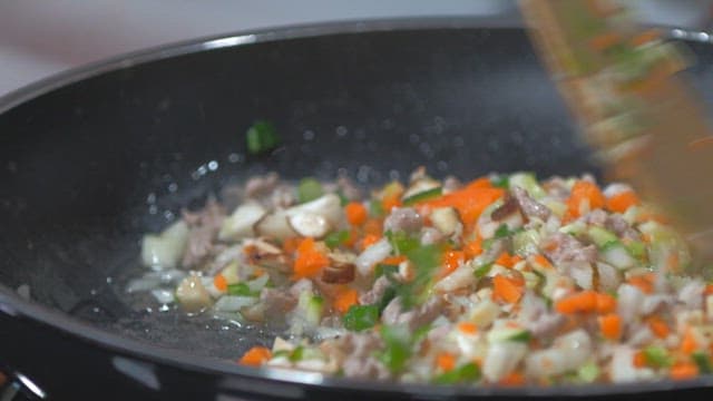 실내에서 다진 채소를 팬에 볶는 사람