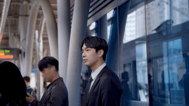 붐비는 지하철 역에서 지하철을 기다리는 직장인 남성