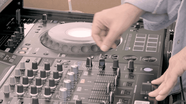 DJ adjusting controls on DJ panel.