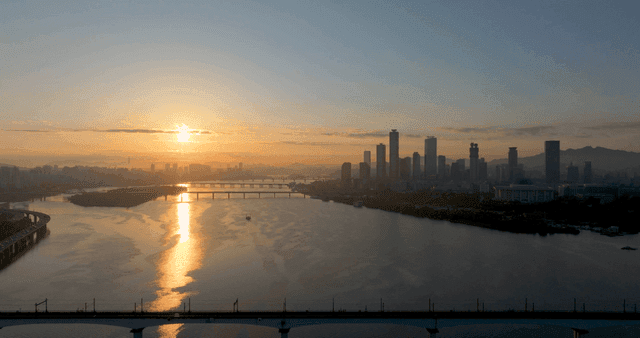 강이 있는 도시 스카이라인 위의 일출