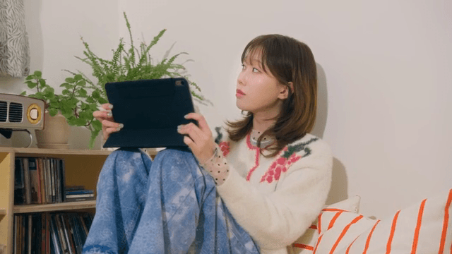 Woman using tablet in cozy room and looking out window