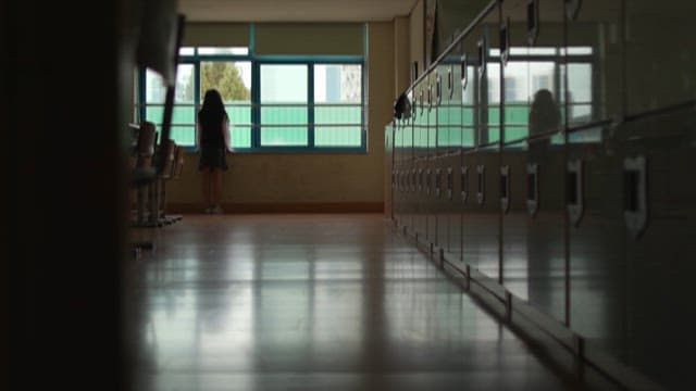 Student Gazing Out From School Hallway