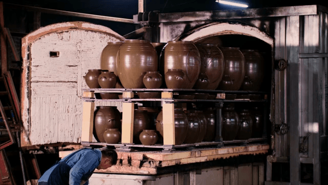가지런히 놓인 전통 항아리를 점검하는 작업자
