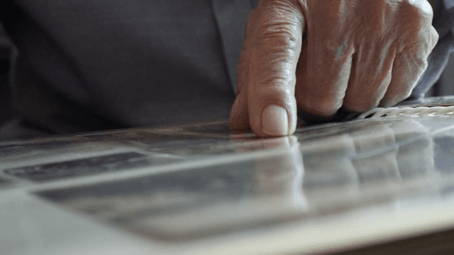 An elderly person looking at a photo album