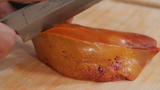 Slicing a piece of liver tingray of on a cutting board