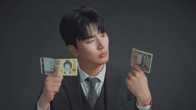 손에 든 일본 엔화를 보고 미소짓는 남자