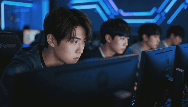 Men focused on gaming in a dark internet cafe