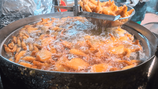 뜰채로 건져지는 잘 튀겨진 만두들