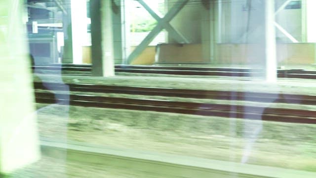 Through the window of a moving train, reflections and blurred scenery