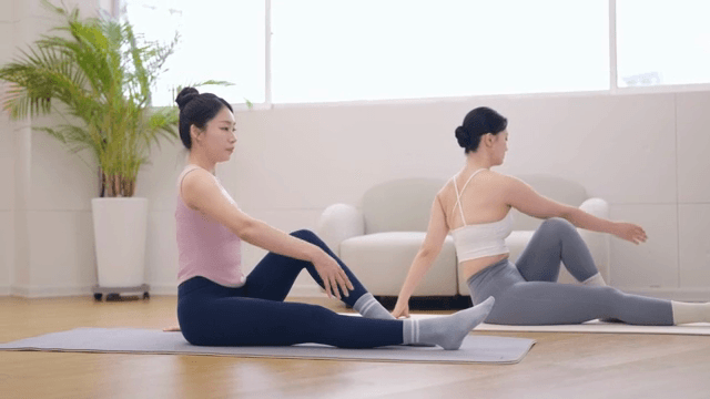 Yoga instructor guiding a student indoors