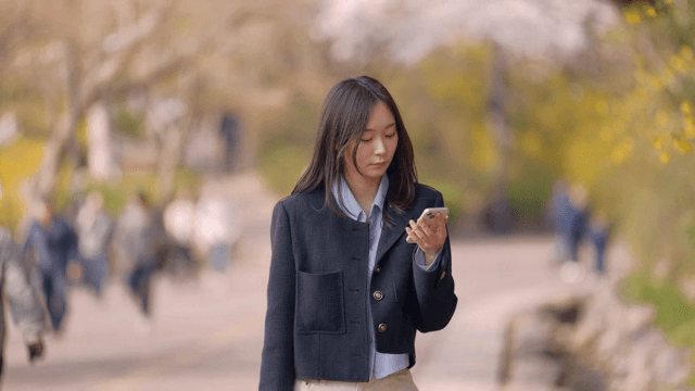 핸드폰을 본 후 표정이 밝아진 채 뛰어가는 여성