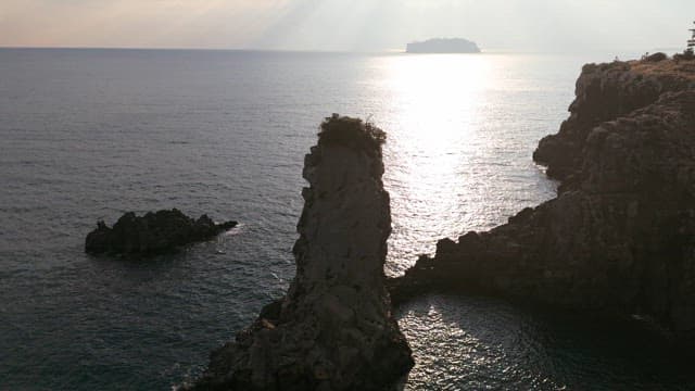 Rocky coastline with sunlight reflecting on the sea