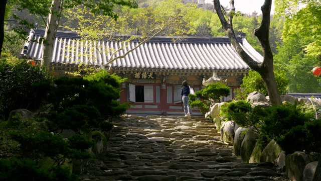 사람이 돌계단을 올라 사찰로 가는 모습