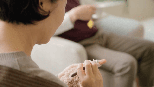 실내에서 뜨개질하는 여성