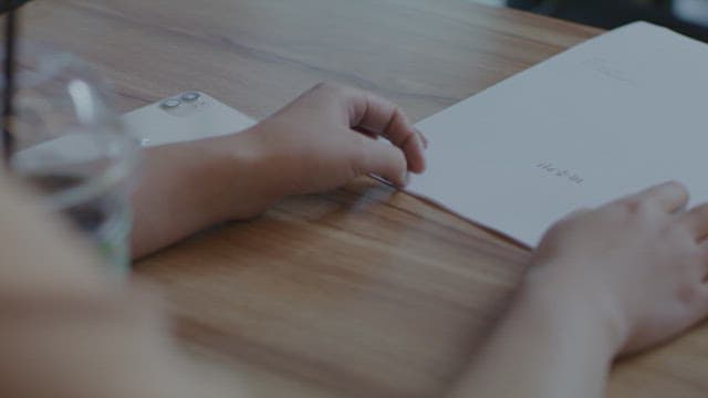 나무 테이블 위에 놓인 종이 서류와 핸드폰