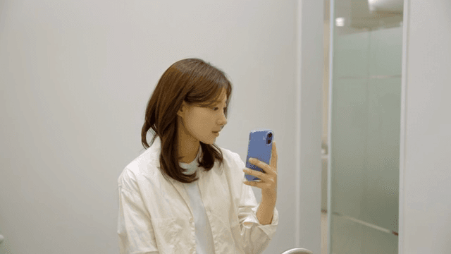 화장실에서 거울 셀카를 찍는 여성