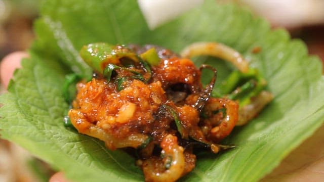 Stir-fried white sundae in perilla leaf served with pickled radish