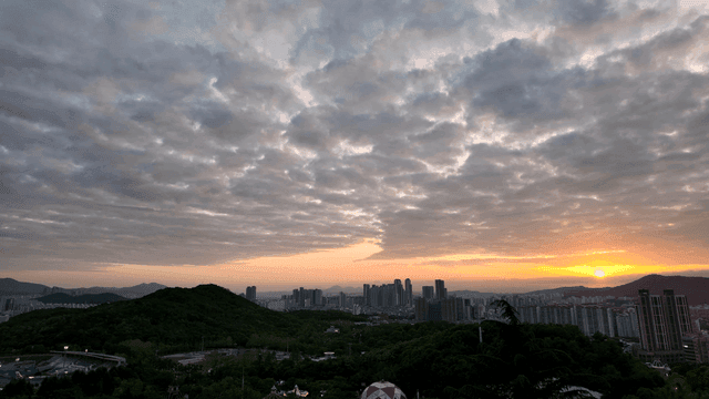 Sunset over a city skyline with clouds
