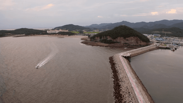 부두와 먼 언덕이 있는 해안 풍경