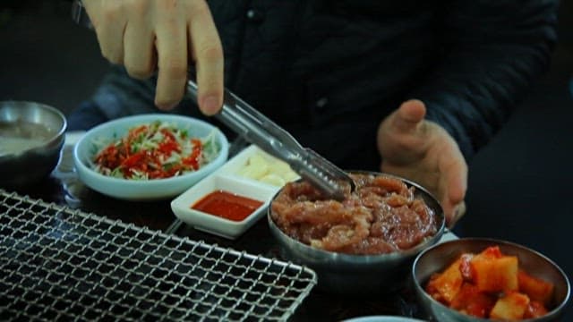 Grilling Meat at a Korean Barbecue Restaurant