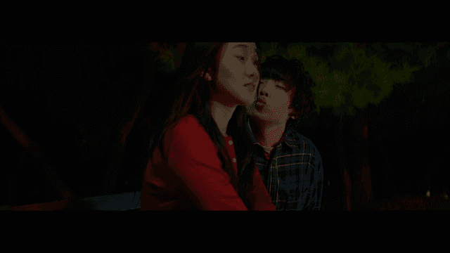 밤 공원 벤치에서 장난스럽게 다가가는 남자와 여자