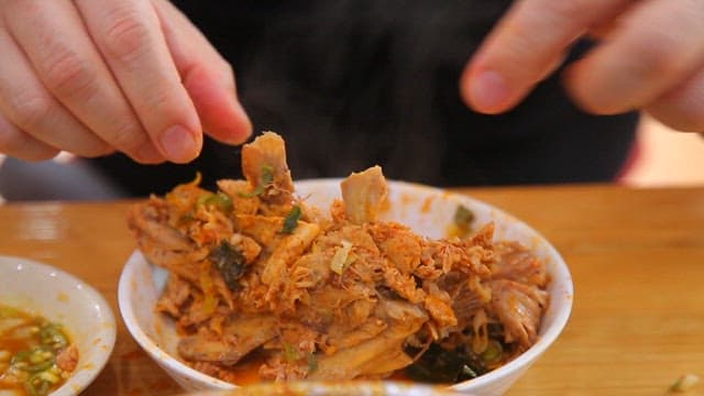 Hands peeling the bones of pork backbone stew meat