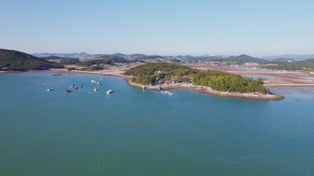 보트와 녹지가 있는 해안 마을