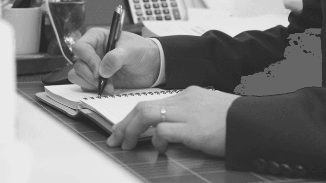 A person writing notes on a paper