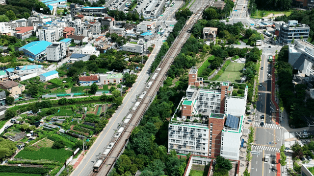 Aerial view of city with greenery where train tracks pass