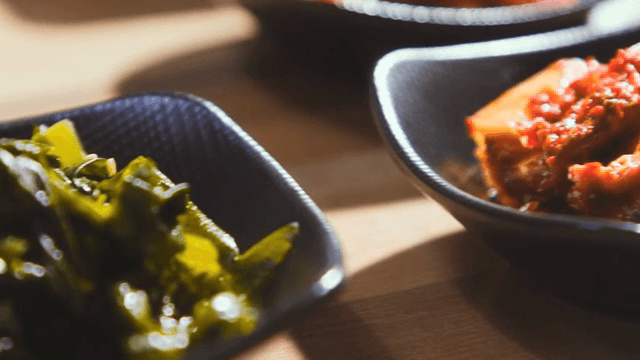 검은 그릇에 담긴 김치와 미역