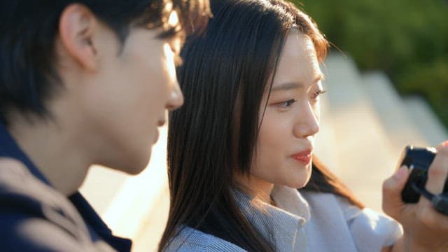 공원에서 캠코더로 영상을 확인하는 커플