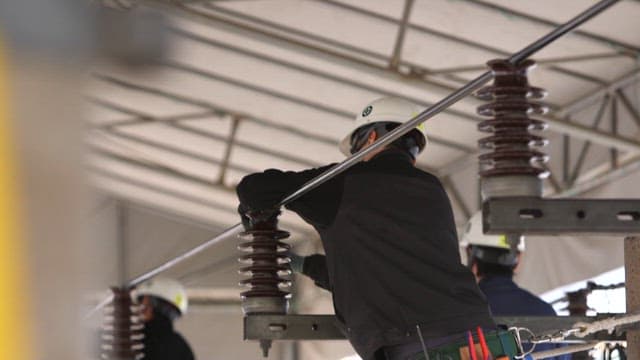 Technicians installing electrical equipment at a construction site