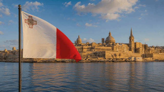 Maltese flag flying near historical landscape