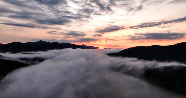 안개 낀 산 위로 떠오르는 일출