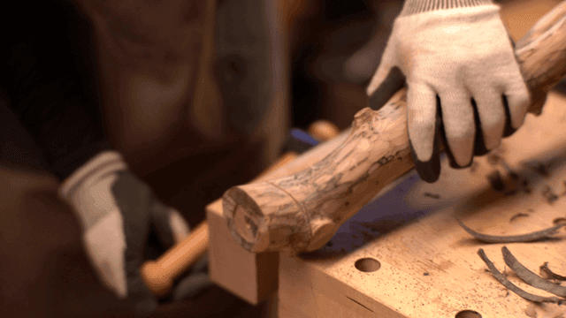 작업장에서 나무를 조심스럽게 톱질하는 모습