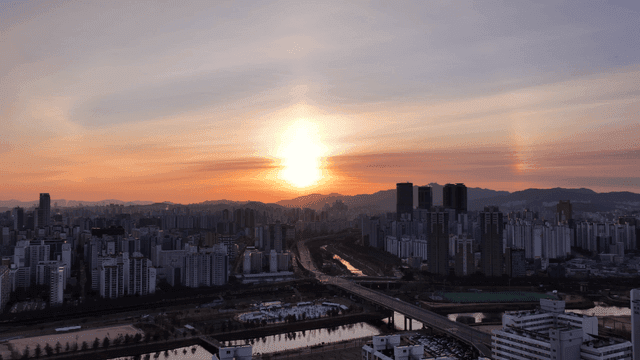Sun setting over city skyline